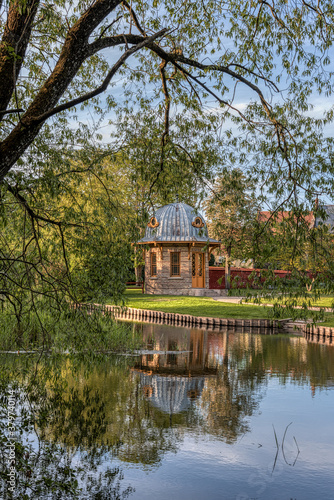 garden pavilion among the trees reflecting in the water