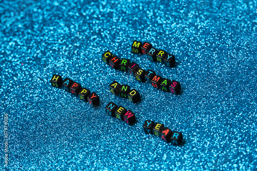 Merry Christmas and Happy New Year greeting card, frame, banner. New Year. Christmas text on shiny blue background. Winter holiday xmas concept