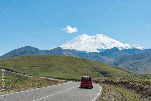 Scenic road view of the highest peak in Europe, mount Elbrus with green hills on a Sunny summer day.