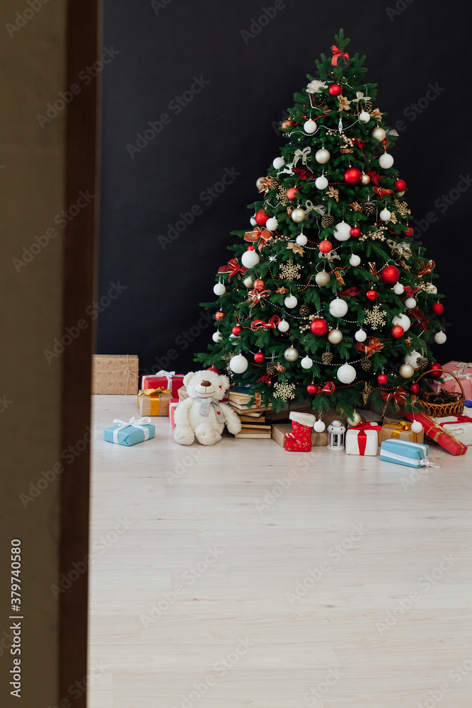 Christmas tree decorated with toys with gifts in the interior of the room black background new year Christmas tree decorated with toys with gifts in the interior of the room black background new year