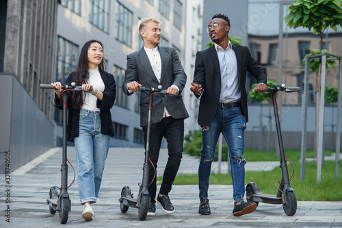 Φωτογραφία Confident happy multiracial office colleagues discussing business project go nea