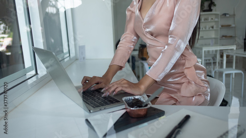Fotografi Portrait of female worker focusing on her work with laptop on worktable in office