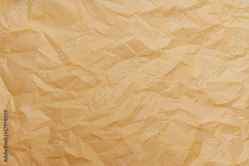 The texture of a crumpled yellow-gold disposable textile napkin.