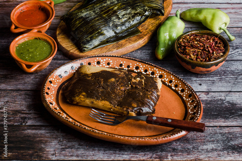 Mexican Tamales Oaxaquenos in banana leaves traditional from Oaxaca Mexico on wooden background photo