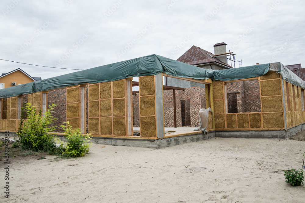 Construction of a house from an environmentally friendly material of plant origin. Frame made of wood, blocks of straw. Construction of a house from an environmentally friendly material of plant origin. Frame made of wood, blocks of straw.