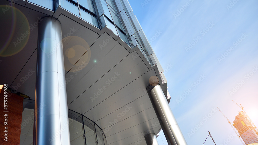 Naklejka premium Office building, details of blue glass wall and sun reflections.