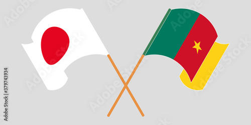 Crossed and waving flags of Cameroon and Japan
