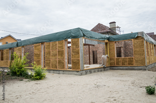 Construction of a house from an environmentally friendly material of plant origin. Frame made of wood, blocks of straw. © Natalia