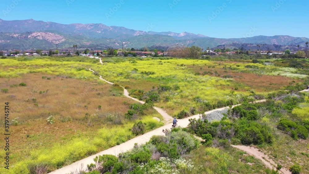 Aerial of a man riding his bicycle bike with Santa Barbara mountains in background near Carpinteria Californa. Aerial of a man riding his bicycle bike with Santa Barbara mountains in background near Carpinteria Californa.