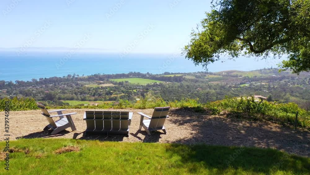 Aerial over outdoor furniture and view of Carpinteria California and establishing Santa Barbara coastline below. Aerial over outdoor furniture and view of Carpinteria California and establishing Santa Barbara coastline below.