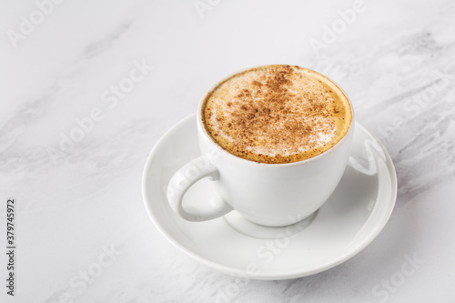Coffee with milk, cappuccino in white cup on marble background, space for text, horizontal format