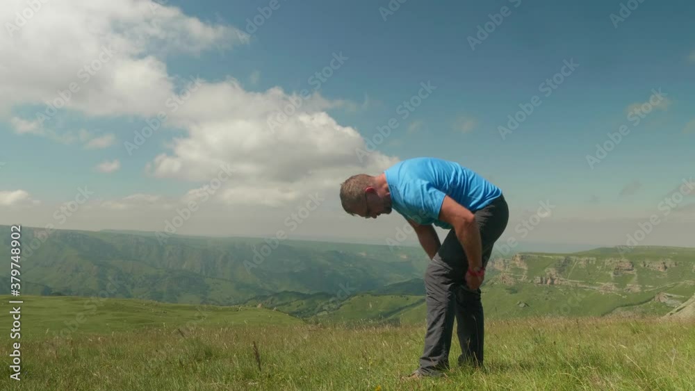 Man in blue t shirt unzips low part of pants and makes shorts on plateau Bermamyth. Greatness of wild nature. Man in blue t shirt unzips low part of pants and makes shorts on plateau Bermamyth. Greatness of wild nature.