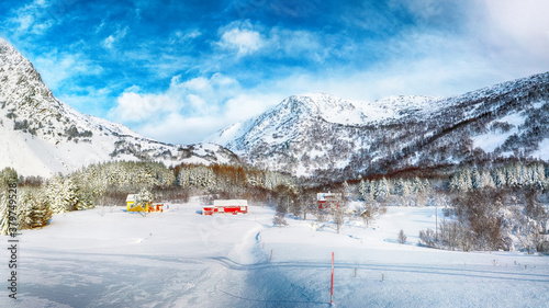 Astonishing winter scenery with traditional Norwegian wooden houses and pine trees near Valberg village at Lofotens. photo