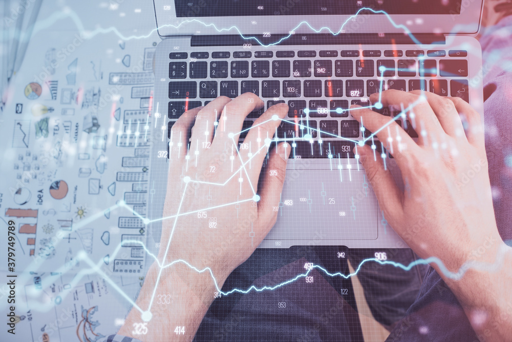 Double exposure of man's hands typing over laptop keyboard and forex chart hologram drawing. Top view. Financial markets concept. Double exposure of man's hands typing over laptop keyboard and forex chart hologram drawing. Top view. Financial markets concept.