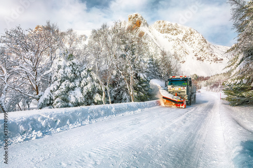 Winter scenery with snowplow truck clearing the road near Valberg