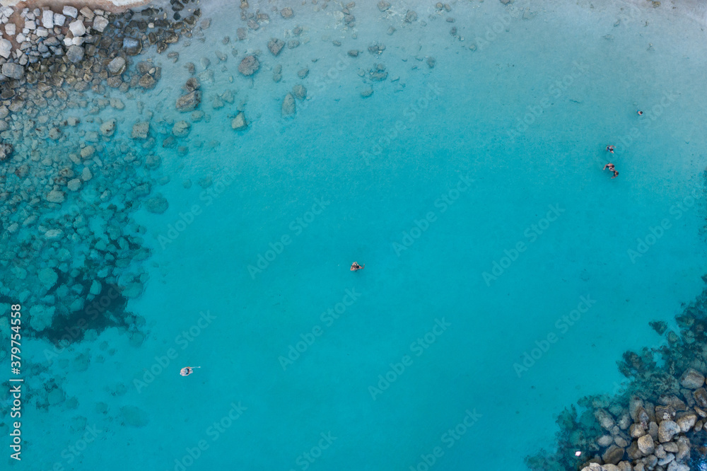 An aerial view of the beautiful Mediterranean Sea and a swimmer, where you can see the cracked rocky textured underwater corals and the clean turquoise water of Protaras, Cyprus, An aerial view of the beautiful Mediterranean Sea and a swimmer, where you can see the cracked rocky textured underwater corals and the clean turquoise water of Protaras, Cyprus,