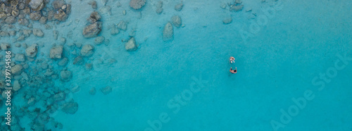 An aerial view of the beautiful Mediterranean Sea and a swimmer, where you can see the cracked rocky textured underwater corals and the clean turquoise water of Protaras, Cyprus,