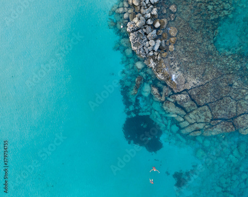 An aerial view of the beautiful Mediterranean Sea, where you can see the cracked rocky textured underwater corals and the clean turquoise water of Protaras, Cyprus,  © Valentinos Loucaides