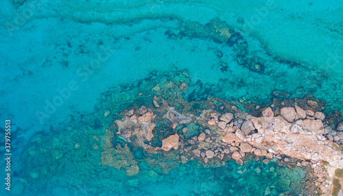 An aerial view of the beautiful Mediterranean Sea, where you can see the cracked rocky textured underwater corals and the clean turquoise water of Protaras, Cyprus, © Valentinos Loucaides