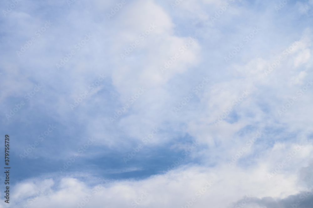 Abstract background of white fluffy clouds on a bright blue sky