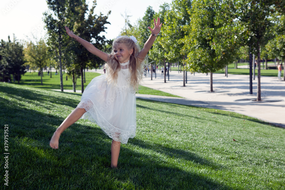 Obraz premium little girl in a dress in the green garden