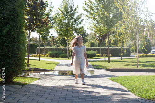 little girl in a white dress go for a walk on sunshine