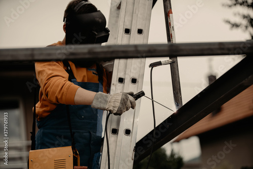 A structural steel worker working on a high rooftop