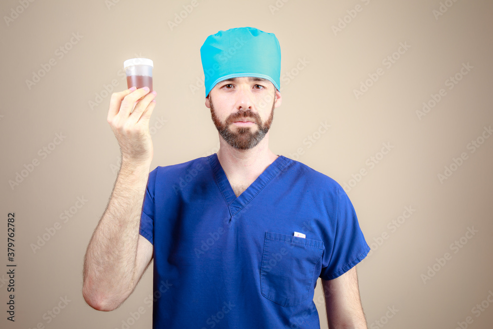 Medico hombre revisa muestra de orina analisis revision medica infeccion retrato Medico hombre revisa muestra de orina analisis revision medica infeccion retrato