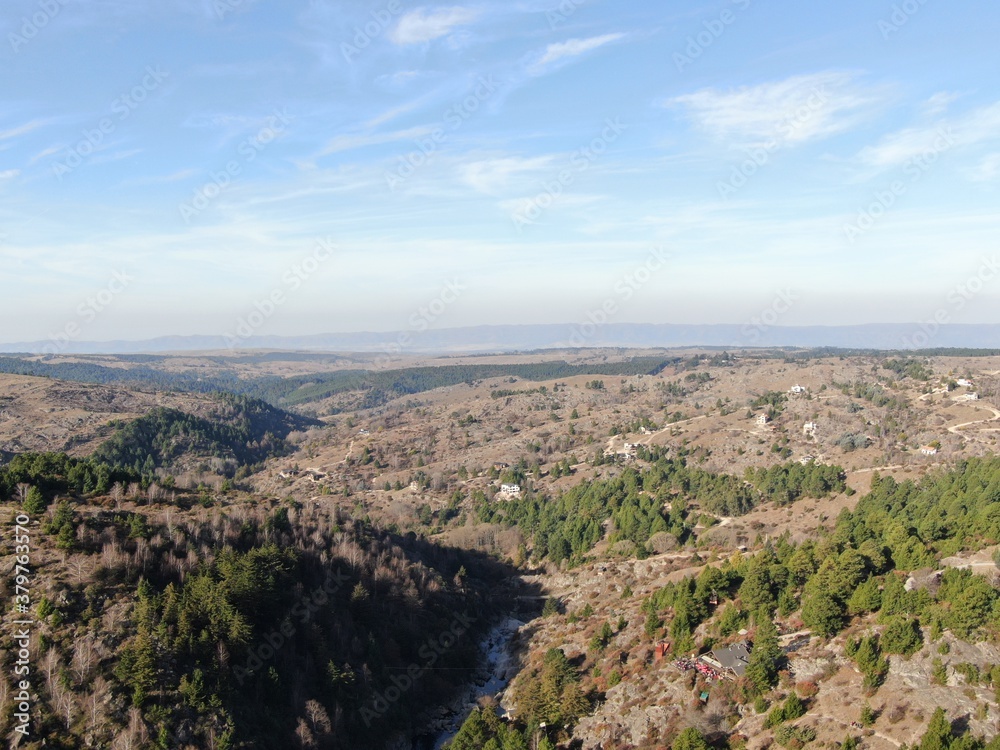 Vista aérea de un río de montaña que circula en un valle cubierto de bosques.