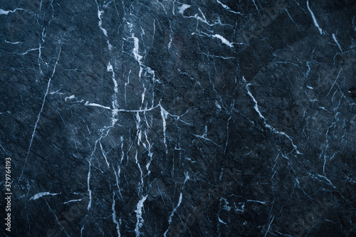 dark abstract marble texture background with blue tint and white veins