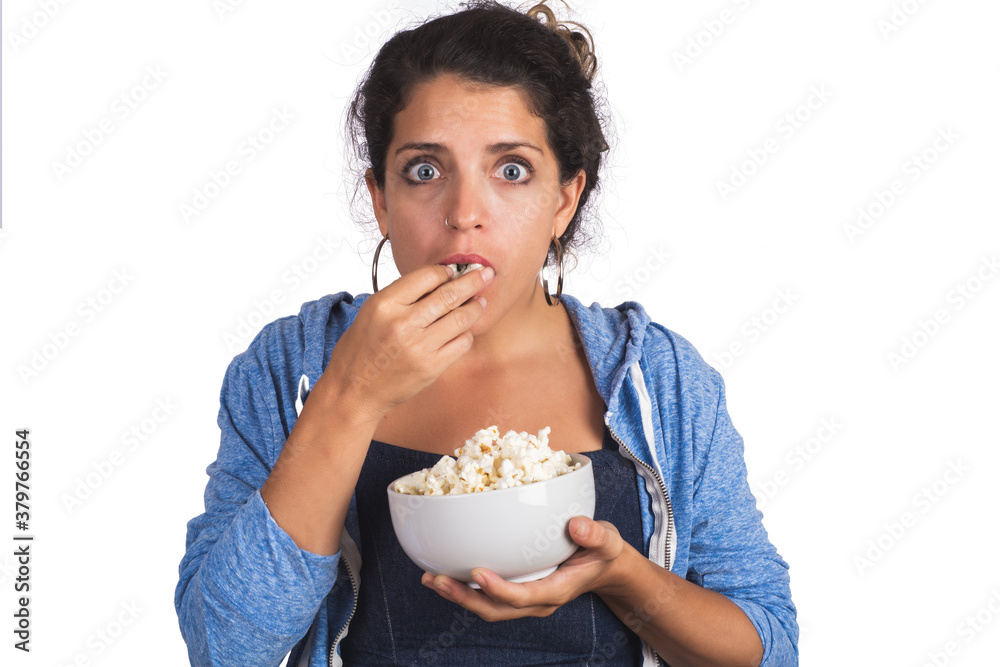 woman watching a movie while eating popcorn. woman watching a movie while eating popcorn.