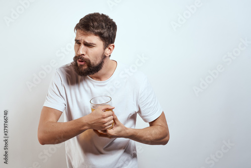 man with a mug of beer in his hands and a white t-shirt light background mustache beard emotions model
