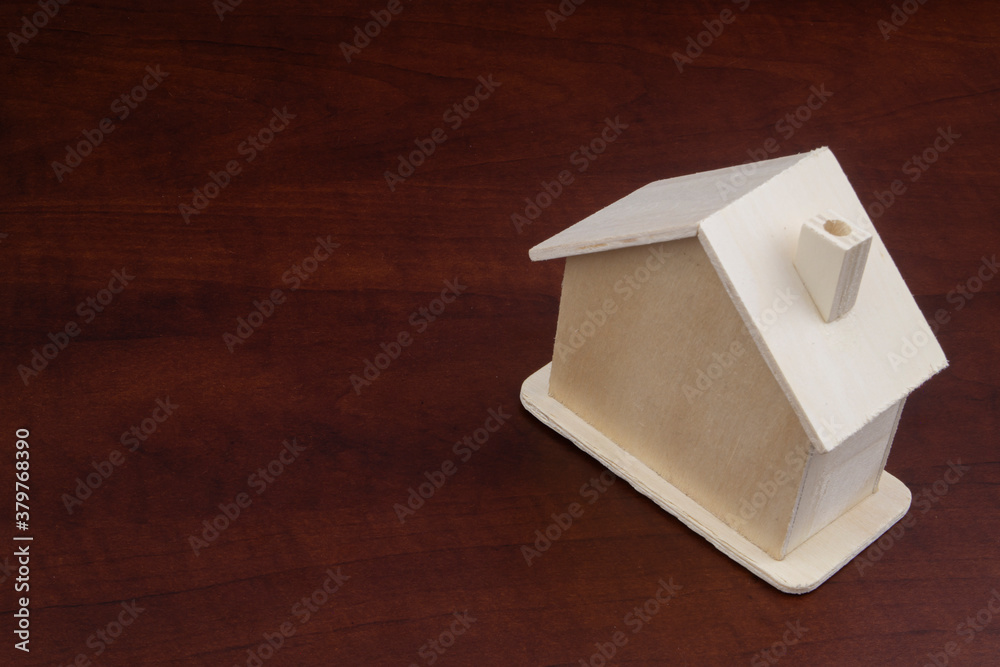 Fototapeta premium Small wooden house on table with copy space, real estate concept