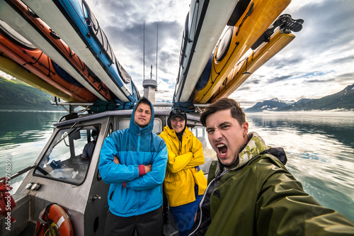 Friends on whale wathcing and kayak expedition having fun on the boat in Alaska trip