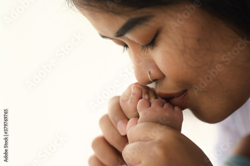 mother gentle kiss hands of her newborn baby