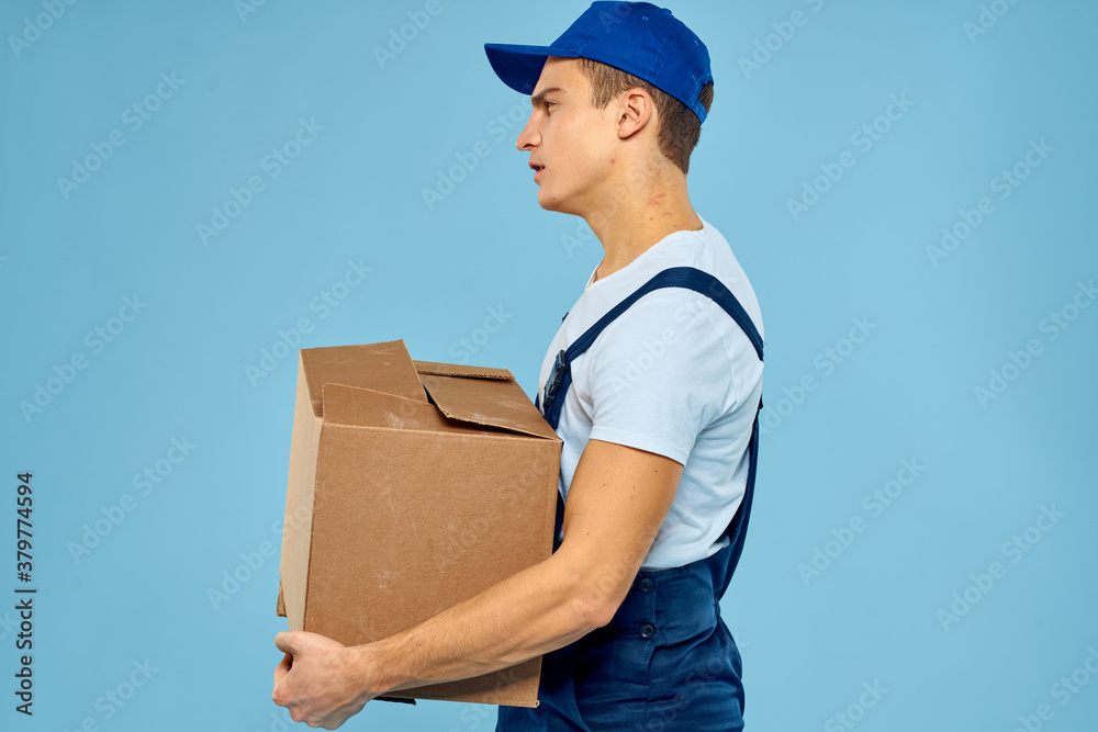 Man worker with cardboard box delivery loader lifestyle blue background Man worker with cardboard box delivery loader lifestyle blue background