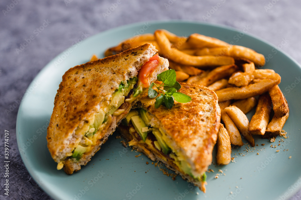 plant-based food, vegan avocado tomato and dairy-free cheese sandwiches with french fries plant-based food, vegan avocado tomato and dairy-free cheese sandwiches with french fries