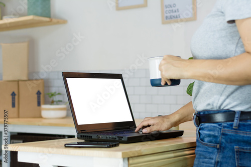 Woman with a laptop and a cup of coffee and background shipping packages