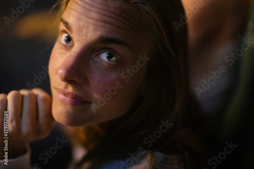 A young woman looks innocently up at the viewer photo