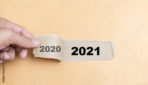 Hand  rip paper with word 2020 and revealing 2021, Conceptual  business planning start new year 2021 photo