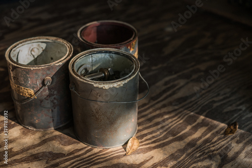 Old Vintage Paint Cans with collections of Harware and Nails photo