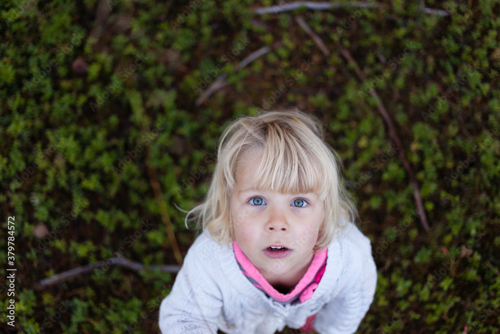 Cute girl looking up straight in the camera. Cute girl looking up straight in the camera.