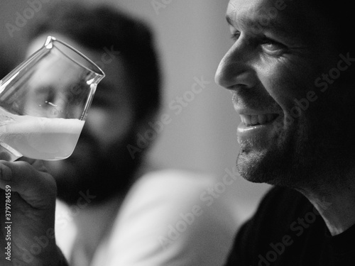 Young man holding glass of alcohol while looking away photo