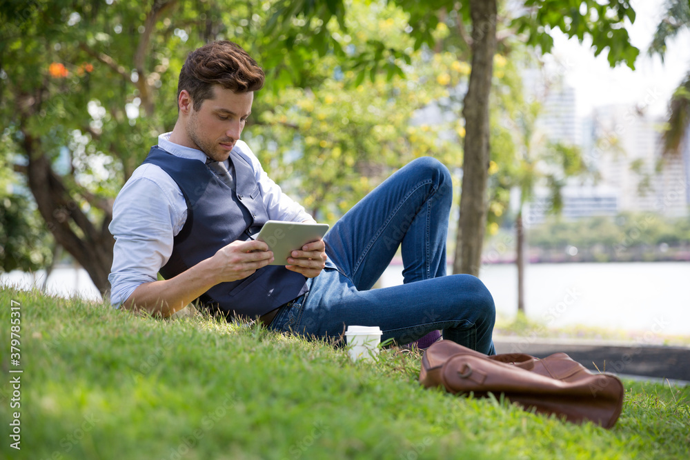 Young business man taking a break in a park - reading a book Young business man taking a break in a park - reading a book
