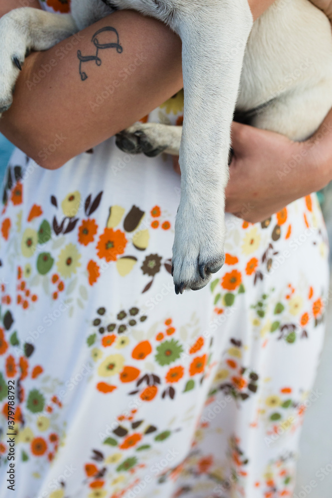Young woman and her pug dog Max by the sea