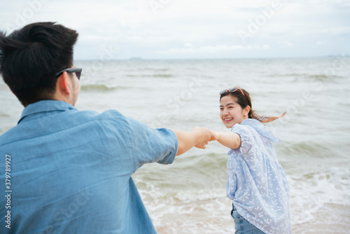 Couple traveler holding hands dace on the beach.