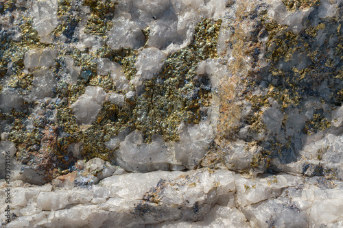 Molybdenite ore in granite. Minerals - molybdenite, pyrite, chalcopyrite, white quartz. Sorskoe deposit, Khakassia, Russia. Concept of mining useful metal - molybdenum. Selective focus.