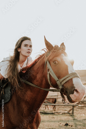 the girl is sitting on a brown horse