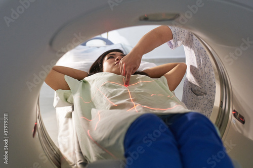 Technician preparing patient undergoing scan of the abdomen photo