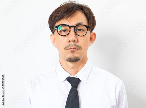 Chinese man wearing white shirt  and tie standing over white background with hand on chin thinking about question.